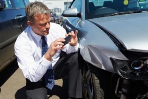 Man taking a picture of a car accident