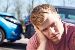 Image of stressed man with a car crash in the background