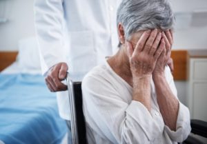 Image of an old woman crying in a nursing home