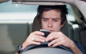 Image of man texting and driving